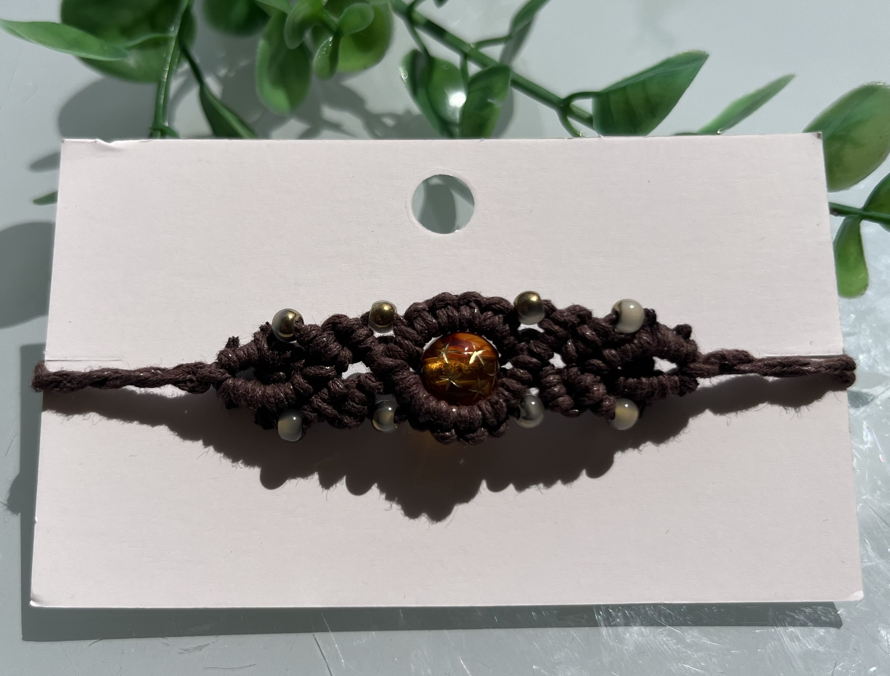 Golden macrame bracelet with woven structure and warm detailing